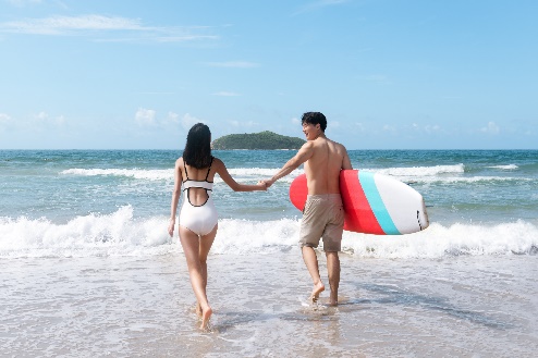 A person and person holding hands and walking on the beach Description automatically generated