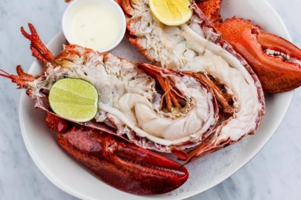 A plate of lobster with lemons and sauces

Description automatically generated